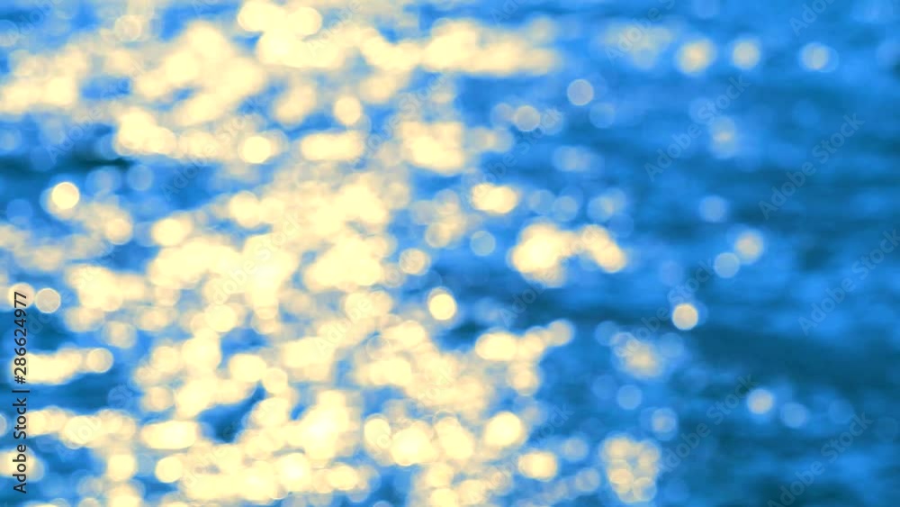 Blurred reflection of sunlight sunset wave on sea surface on afternoon blue orange and white bokeh blink Blurred reflection of sunlight sunset wave on sea surface on afternoon blue orange and white bokeh blink
