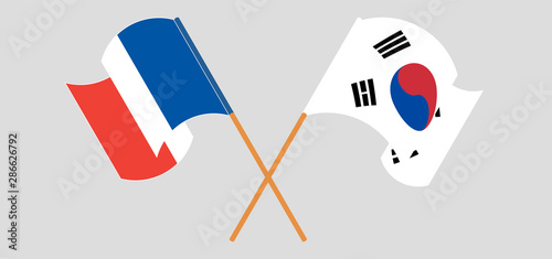 Crossed and waving flags of France and South Korea