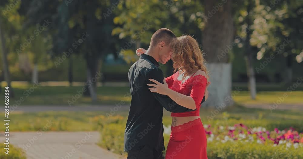 Dancing partners rehearse the dance, support on the move. Tango on the street, passionate movements. Portrait view. Dancing partners rehearse the dance, support on the move. Tango on the street, passionate movements. Portrait view.