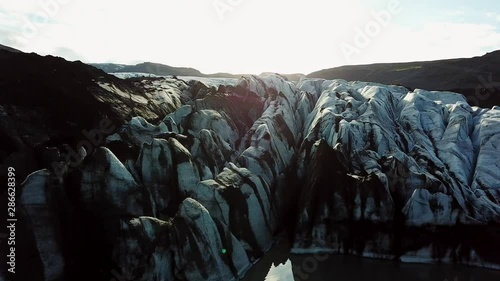 Aerial, tracking, drone shot, of details, on the Sollheimajokull Glacier, at the Jokulhlaups glacial lagoon, near Myrdalsjokull, on a sunny day, in southern Iceland photo