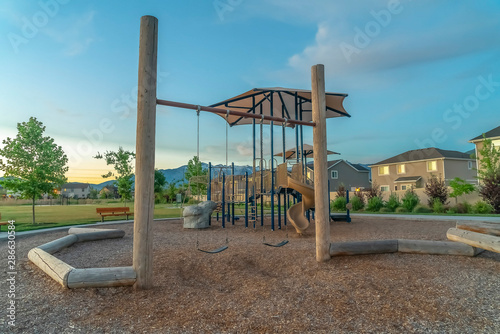Playground and homes on a neighborhood with view of mountain and cloudy blue sky