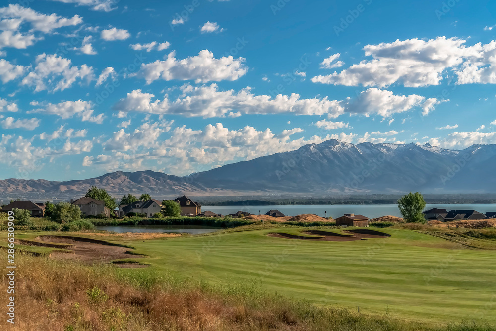 Scenic view of homes golf course pond lake and mountain on a sunny day Scenic view of homes golf course pond lake and mountain on a sunny day