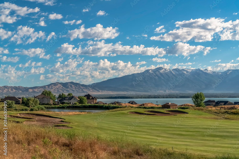 Scenic view of homes golf course pond lake and mountain on a sunny day