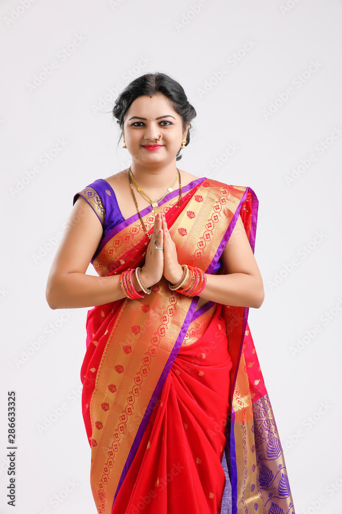  young Indian woman wearing  Sari  and showing a welcome gestures, isolated on white background