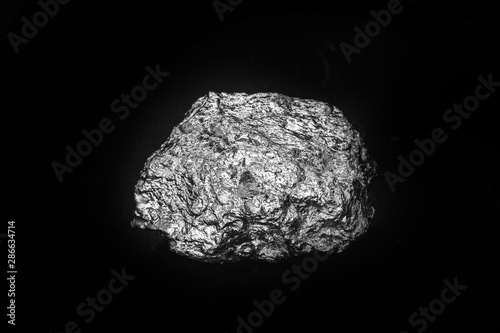 Aluminum stone on isolated black background. Aluminum is a chemical element, at room temperature it is solid, being the most abundant metallic element of the earth's crust.
