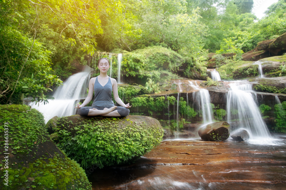 Fototapeta Woman practice yoga with beautiful waterfall