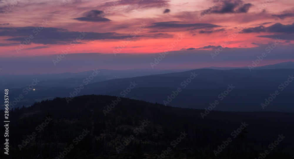 Sunset with distant hill from Tristolicnik. Blue hour. Sumava National Park and Bavarian Forest, Czech republic and Germany