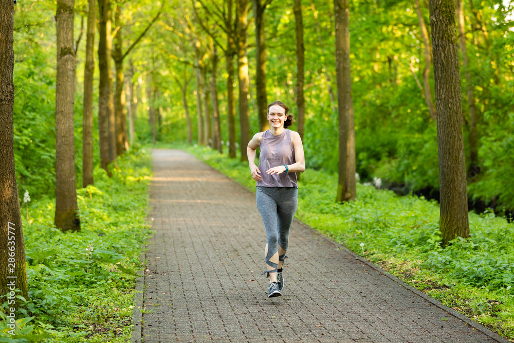 young woman runs in a forest and makes fitness young woman runs in a forest and makes fitness