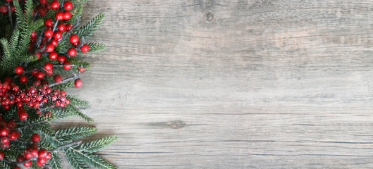 Christmas Holiday Evergreen Pine Branches and Red Berries Over Wood Background, Copy Space