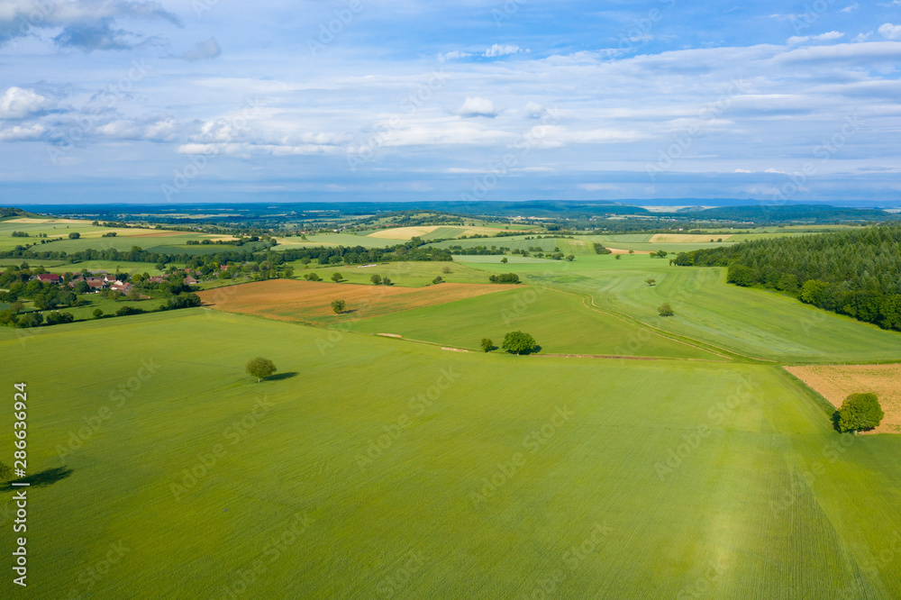 Naklejka premium La campagne et un village français au milieu des champs