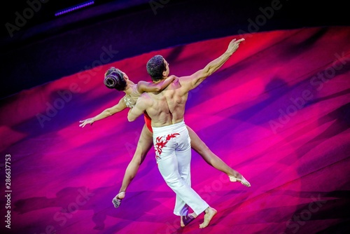 A pair of gymnasts performing at the circus