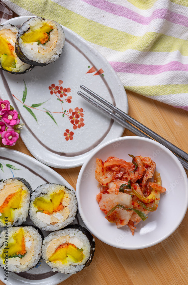 Kimchi and Gimbap serving on white plate