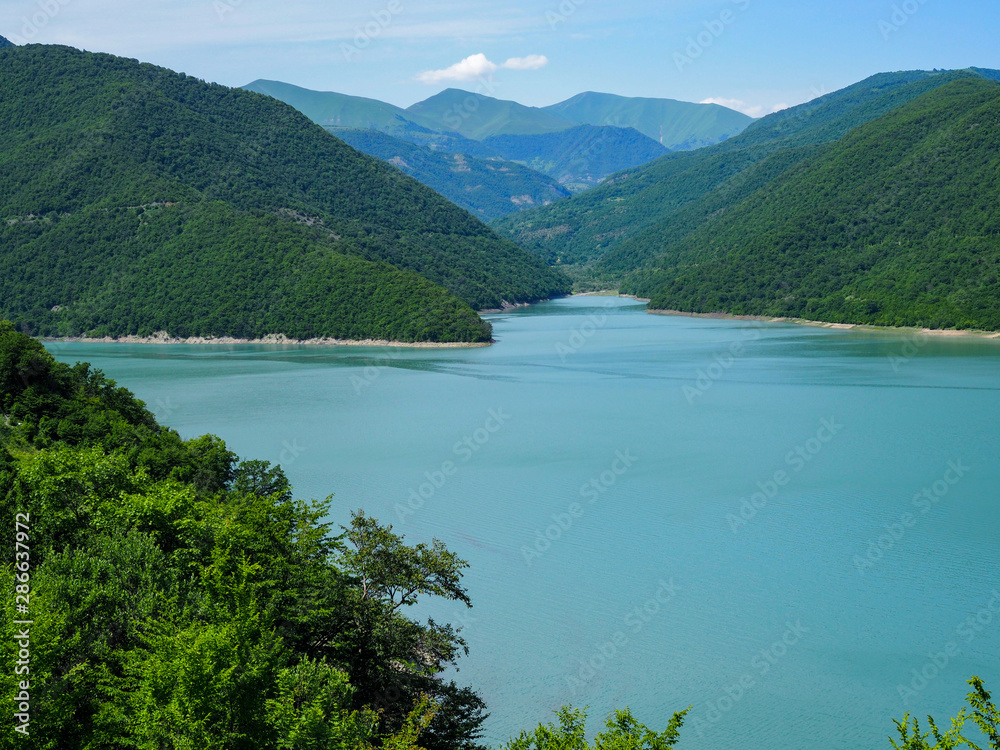 beautiful landscape overlooking a large blue lake in the mountains covered with forest