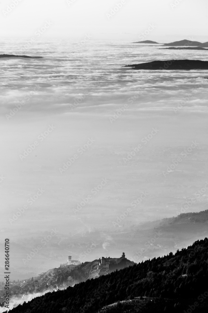 A view from Subasio mountain of Assisi town (Umbria, Italy) in the middle of mist,