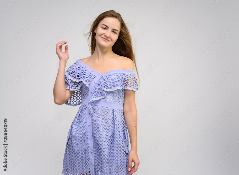 Studio portrait of a knee-length of a pretty girl student, brunette young woman with long beautiful hair in a dress on a white background. Smiling, talking, showing emotions Studio portrait of a knee-length of a pretty girl student, brunette young woman with long beautiful hair in a dress on a white background. Smiling, talking, showing emotions