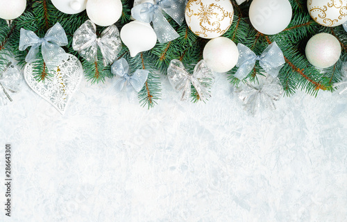 Christmas composition. Christmas gift, knitted blanket, pine cones, fir branches on wooden white background. Flat lay, top view, copy space