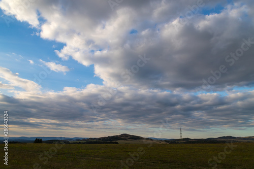 Beautiful sky with clouds over field and mountain