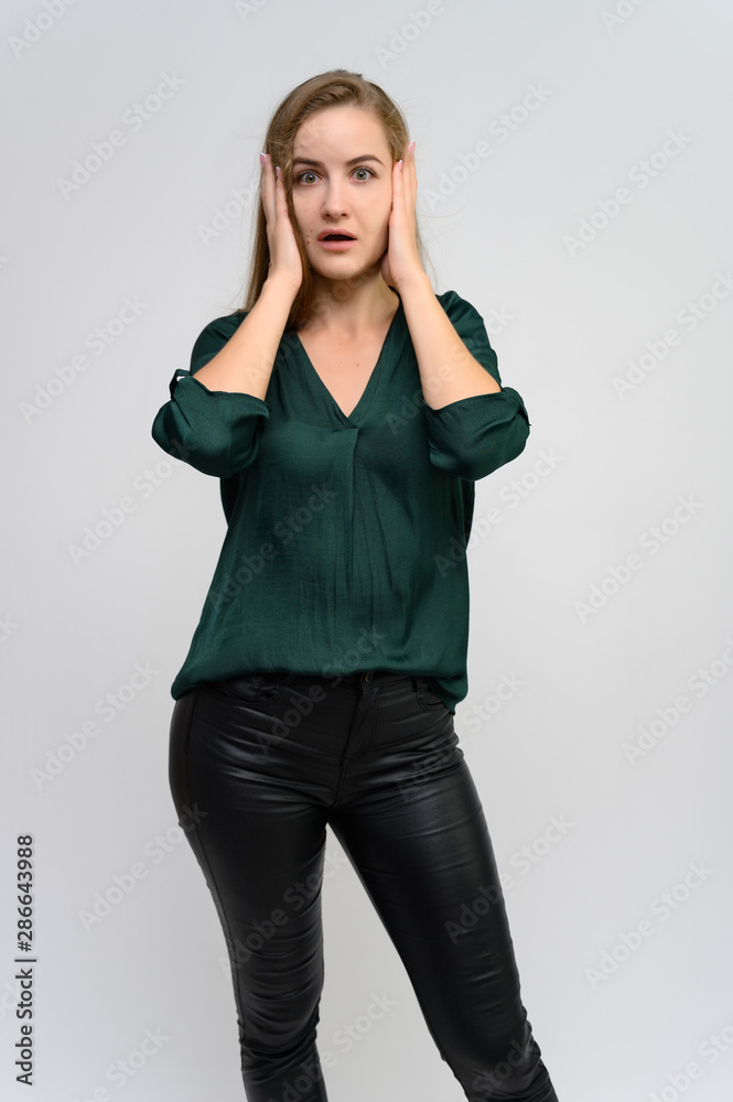 Studio portrait of a knee-length of a pretty student girl, a young brunette woman with long beautiful hair in a green blouse and black pants on a white background. Smiling, talking, showing emotions Studio portrait of a knee-length of a pretty student girl, a young brunette woman with long beautiful hair in a green blouse and black pants on a white background. Smiling, talking, showing emotions