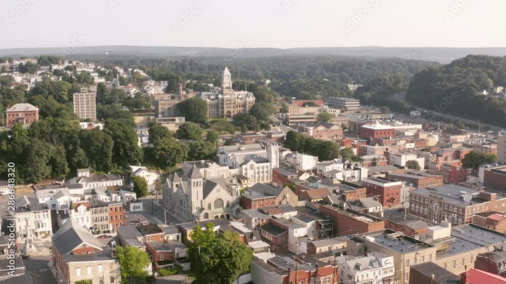 Aerial drone shot flying over a small town in central Pennsylvania heading towards a historic courthouse on a sunny morning. Aerial drone shot flying over a small town in central Pennsylvania heading towards a historic courthouse on a sunny morning.
