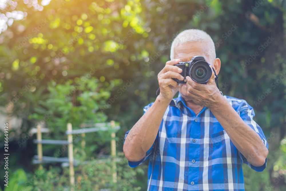 Senior man using a camera to take photo Senior man using a camera to take photo