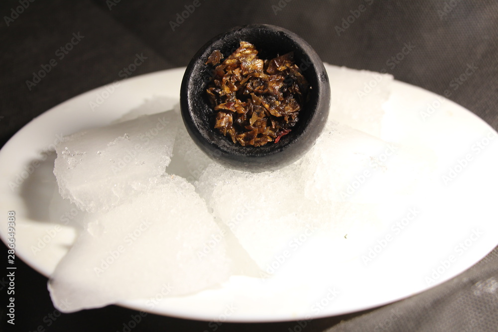 Fototapeta premium bowl with tobacco for hookah. berries on a black background