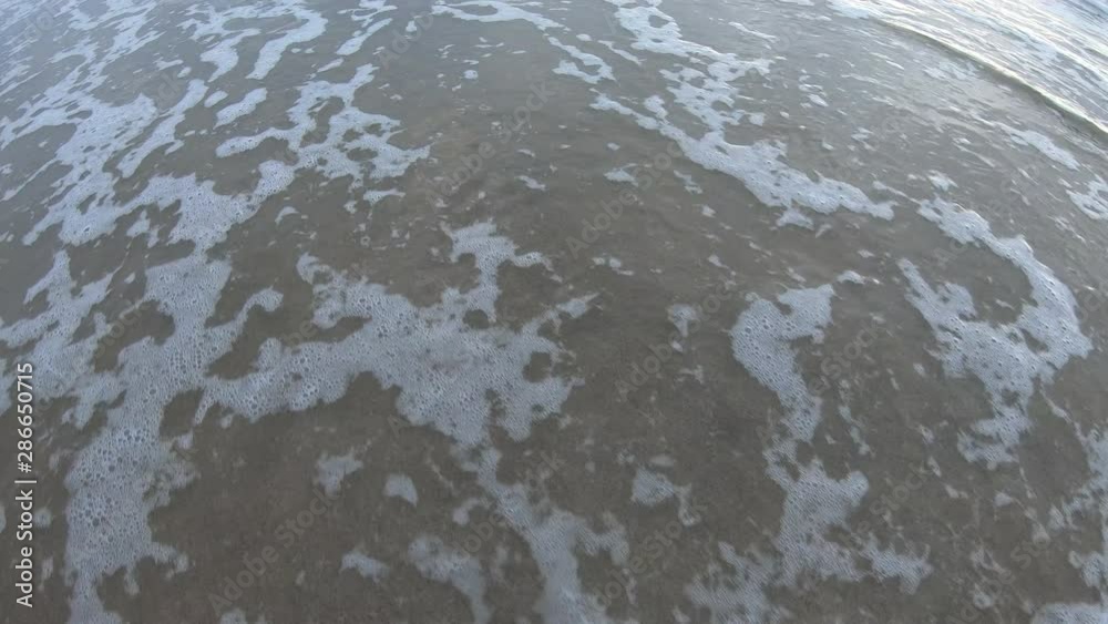 Beach written in the sand being washed away by water from wave at the beach. Beach written in the sand being washed away by water from wave at the beach.