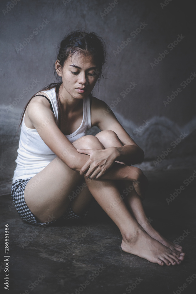 Fototapeta premium Women sitting on the floor with depression, family problems, Domestic violence, Stop violence and abuse ,sexual abuse, human trafficking, rape, The concept of depression and suicide,