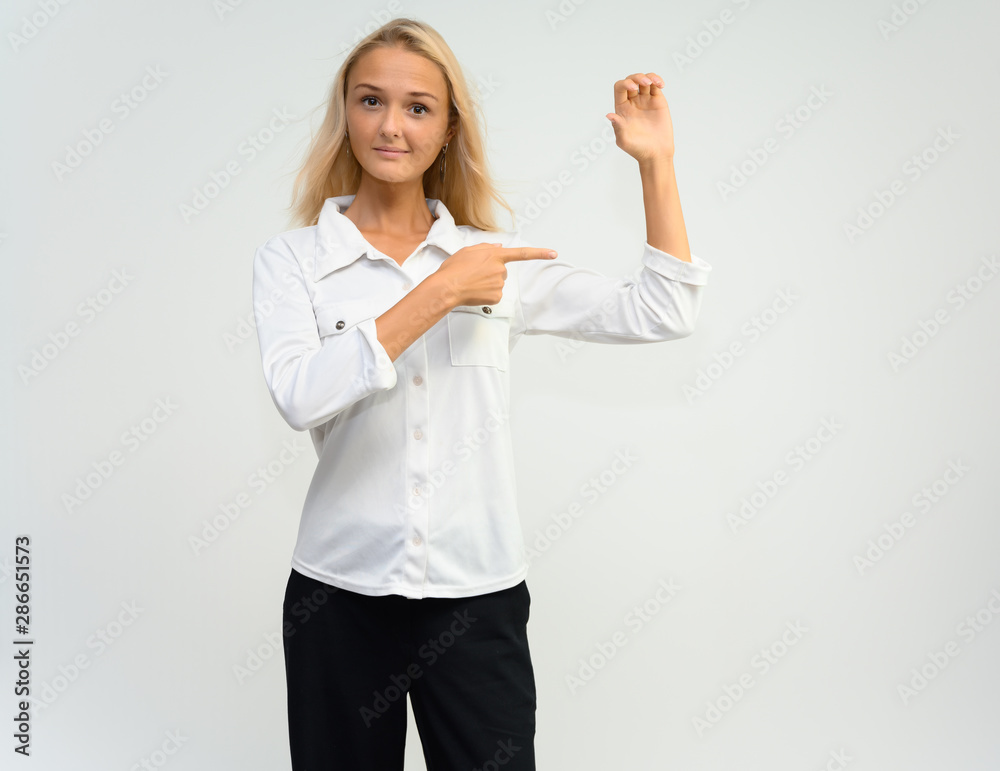 Studio portrait of a pretty blonde student girl, young woman in a white shirt on a white background. Talking, showing emotions. Studio portrait of a pretty blonde student girl, young woman in a white shirt on a white background. Talking, showing emotions.