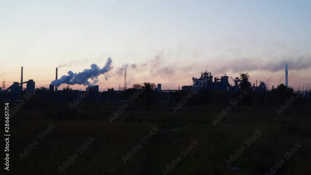 Smoke from the chimneys of a metallurgical plant against the sky at dawn Smoke from the chimneys of a metallurgical plant against the sky at dawn