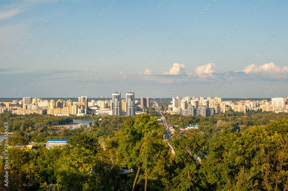 Fototapeta premium View of the city of Kiev, the Dnieper River. City panorama with a place across the river, park, summer day.