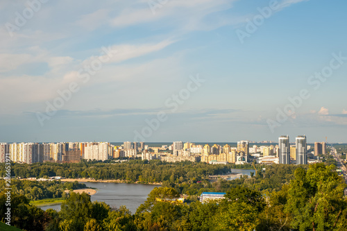 View of the city of Kiev, the Dnieper River. City panorama with a place across the river, park, summer day.