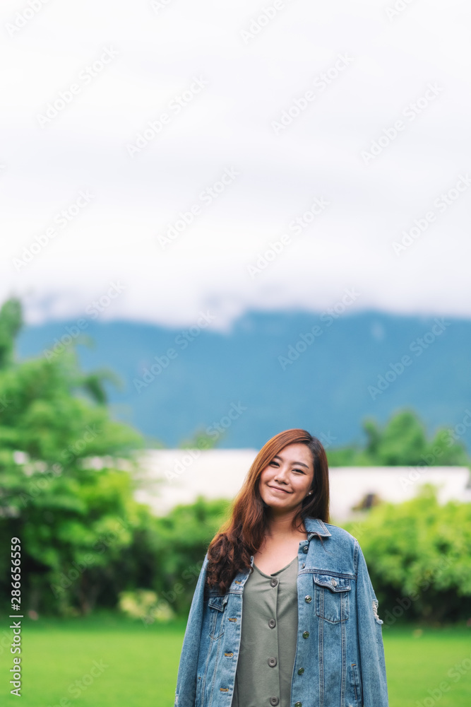 Portrait image of an asian woman standing in front of a beautiful mountain view in foggy day Portrait image of an asian woman standing in front of a beautiful mountain view in foggy day