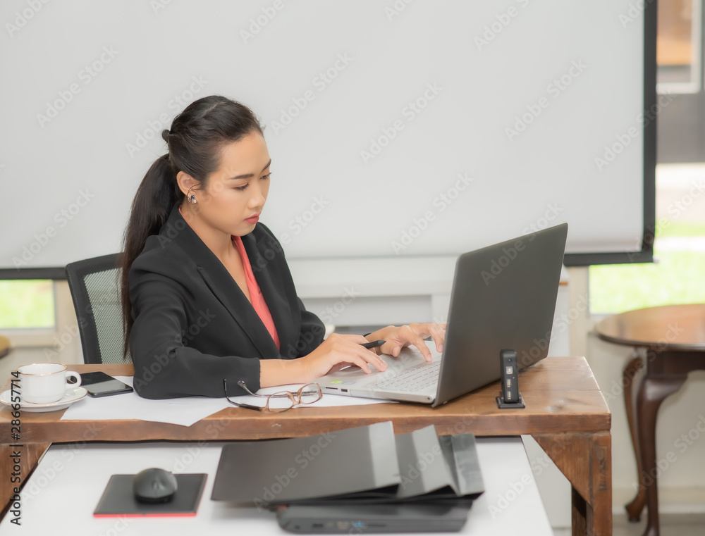 Young pretty business woman with notebook in the bright modern office indoors. Young pretty business woman with notebook in the bright modern office indoors.