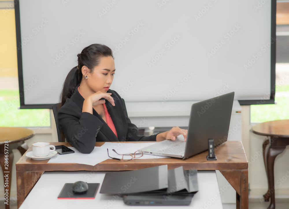 Young pretty business woman with notebook in the bright modern office indoors. Young pretty business woman with notebook in the bright modern office indoors.