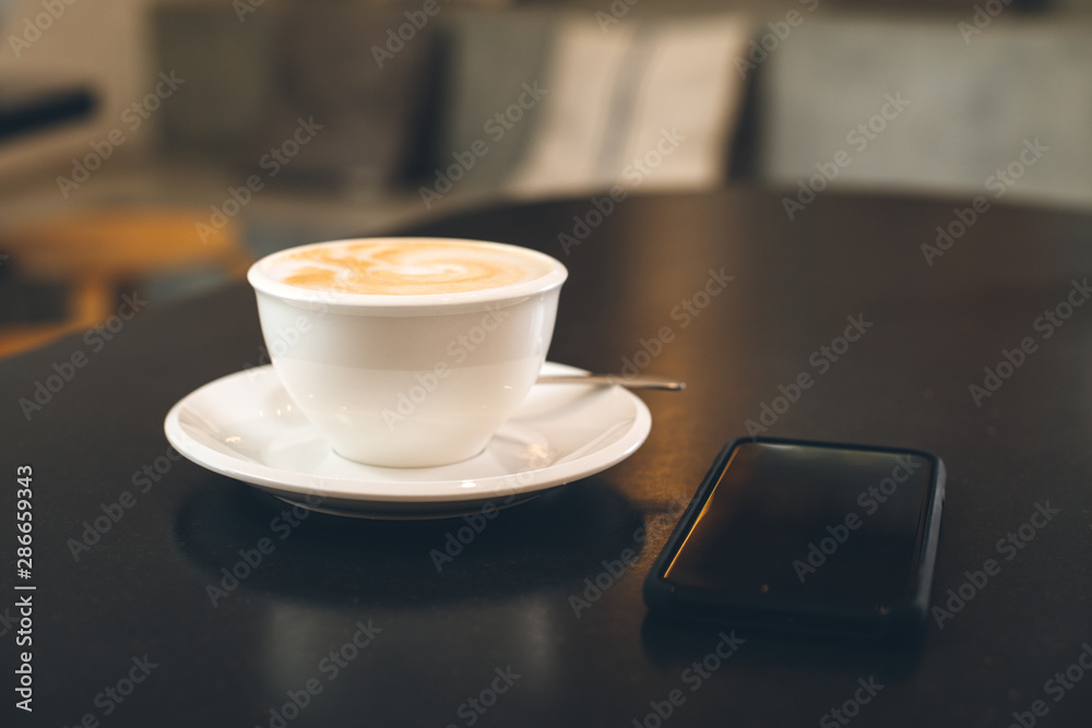 simple solo white cup of coffee with foam milk on black table