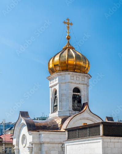 Golden small dome of Cathedral of Christ the Saviour, the second tallest Orthodox church in the world, landmark of Moscow, Russia, under blue sky in summer season photo