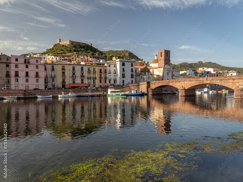 Sunset view at medieval city Bosa with river and houses reflected in Temo river