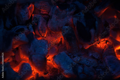 Hot coals in a bonfire. Red-hot red embers of a barbecue. Burning fire