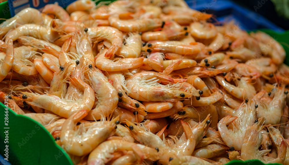 Fresh shrimps or prawns raw on a market counter. Fresh seafood, mediterranean diet. Background texture. Fresh shrimps or prawns raw on a market counter. Fresh seafood, mediterranean diet. Background texture.