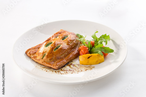 Puff pastry bun with spinach and tomato and lemon on the side isolated on white background