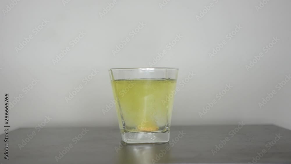Dissolve vitamin effervescent tablet in a glass of water, to get power for life. Close Up Shot. Dissolve vitamin effervescent tablet in a glass of water, to get power for life. Close Up Shot.