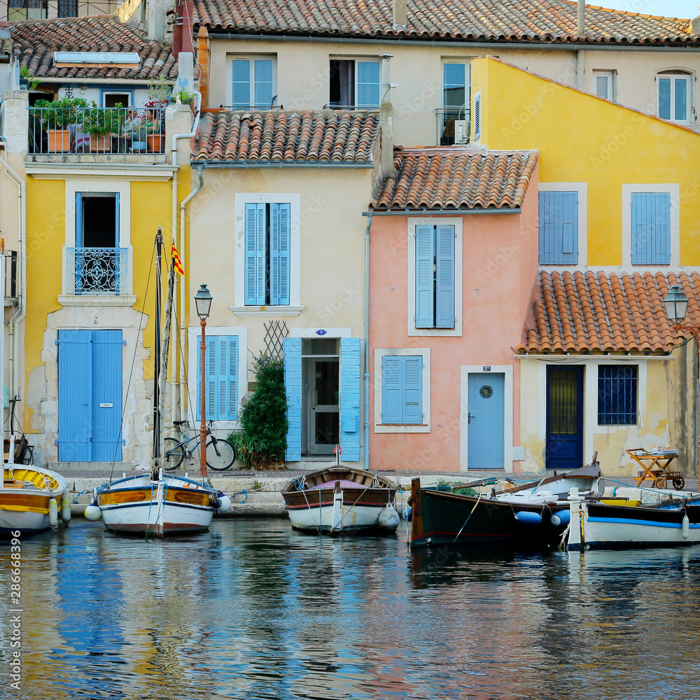facade of mediterranean building with colorful shutter with river and boat facade of mediterranean building with colorful shutter with river and boat
