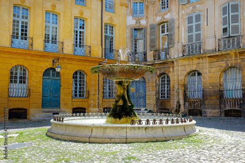stone fountain in mediterranean city with historical building 