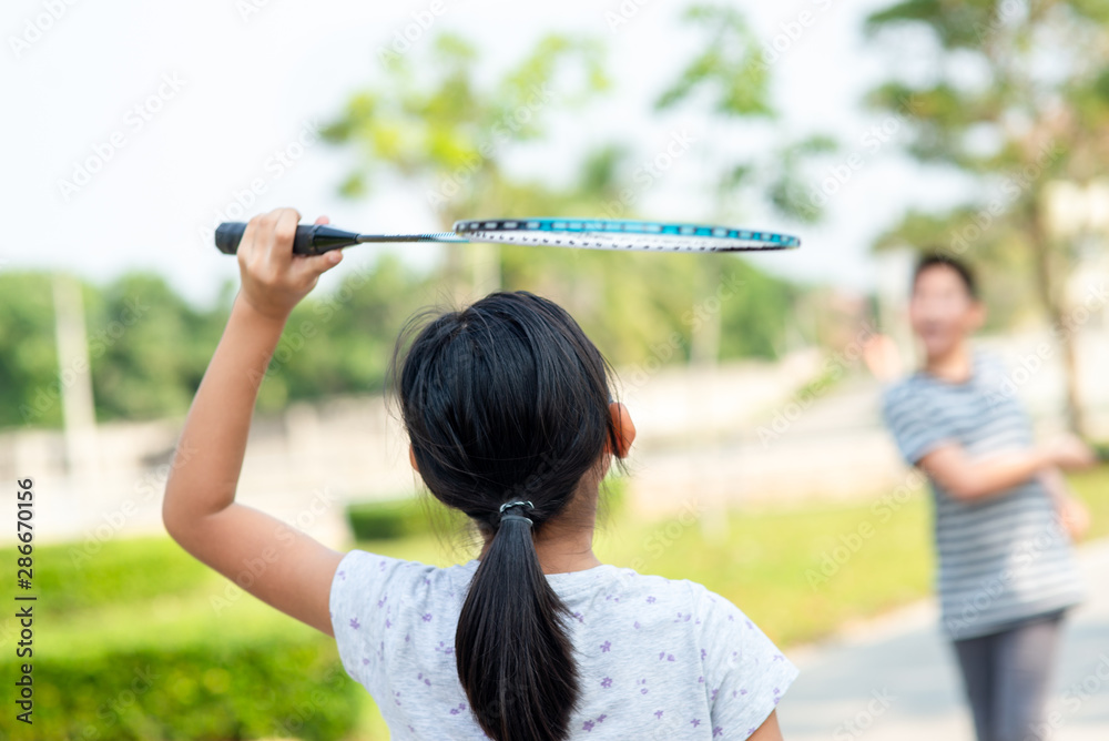 Motion blur back of girl playing badminton with friend outdoor. Motion blur back of girl playing badminton with friend outdoor.