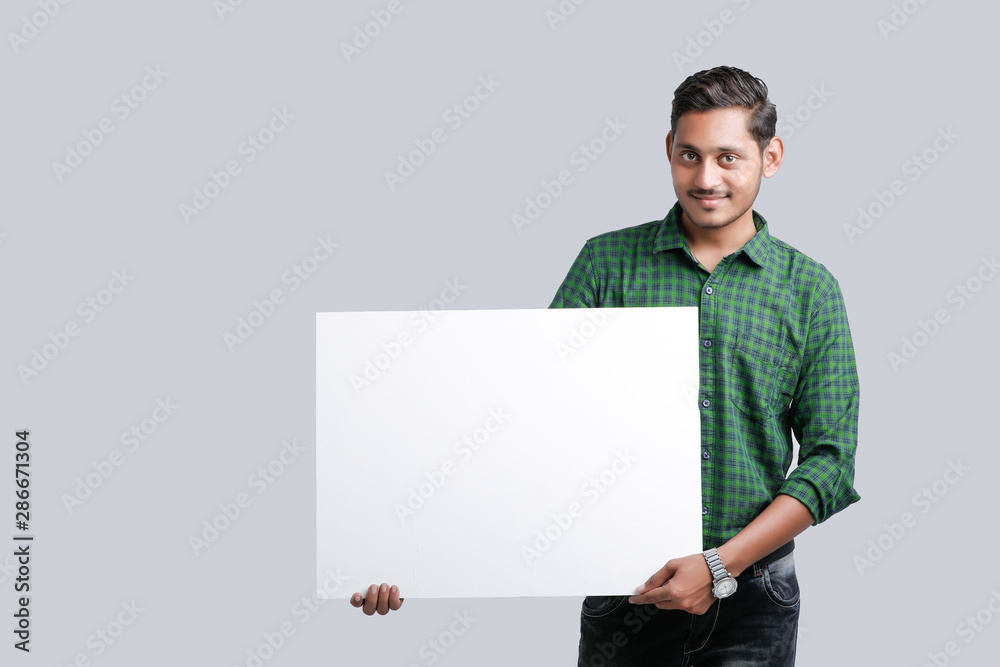 young indian guy holding blank poster young indian guy holding blank poster