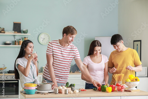 Happy friends cooking toget...