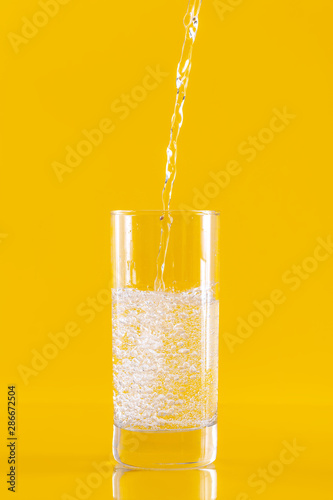 Cold water pouring from a bottle into a glass