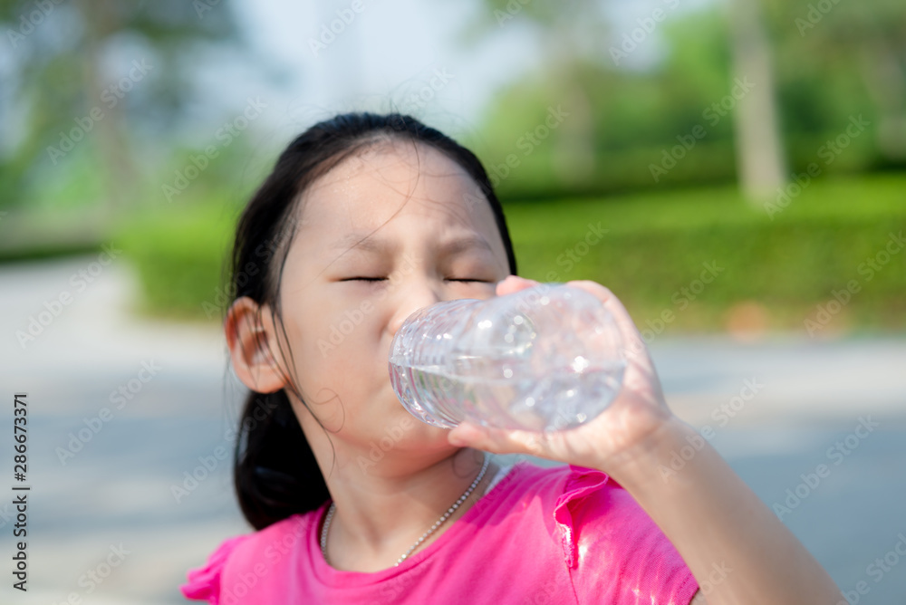 Happy Asian girl drinking a bottle of water outdoor. Happy Asian girl drinking a bottle of water outdoor.
