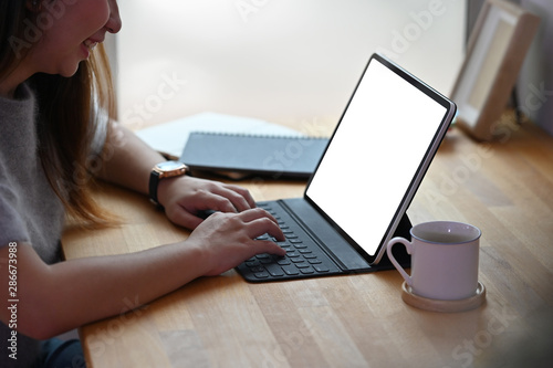 Cropped shot young woman's hands using mockup tablet with empty screen display.
