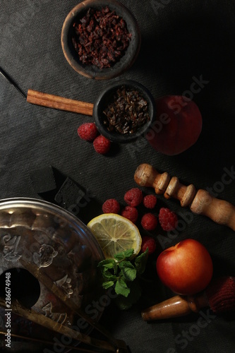 bowl with tobacco for hookah. berries on a black background